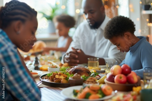 A family gathers around a table  hands clasped in unity  before digging into a delicious feast