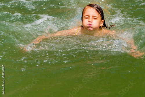 Close up carefree young girl relaxing  swimming in water in mountain lake. People in nature. Copy space.