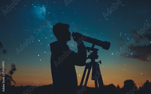 Silhouette of an astronomer using a telescope to gaze at the star-filled Milky Way galaxy on a clear night.