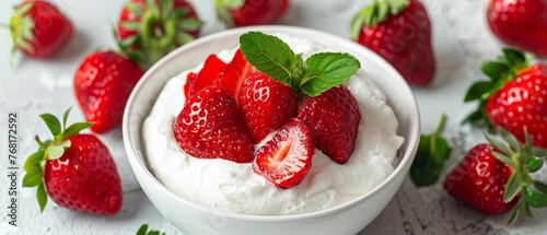 A bowl of ripe, juicy strawberries topped with a dollop of whipped cream, ready to be enjoyed on a textured surface.