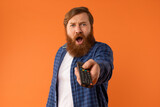 Shocked Bearded Man Watching Television Pointing Remote Controller In Studio