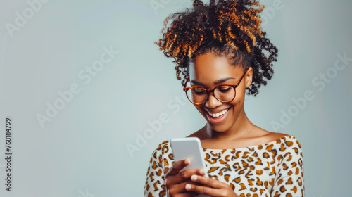 Happy African American woman with glasses texting on phone photo