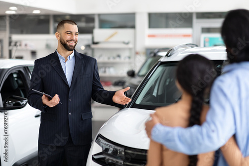 Car salesman explaining features to a hindu couple