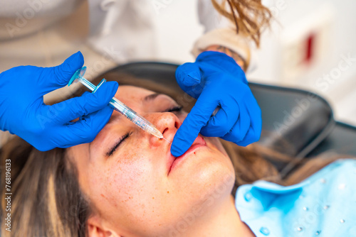 Doctor applying botox therapy on lips of a patient