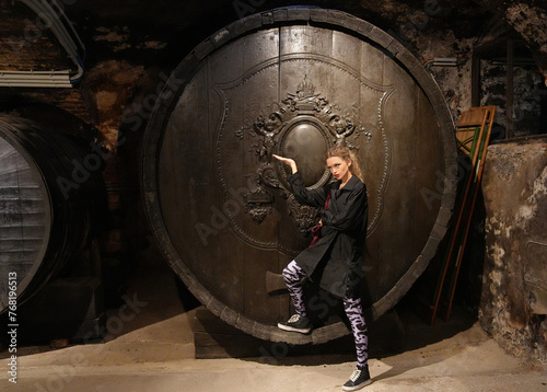 blonde girl posing in Front of an Antique Wine Barrel