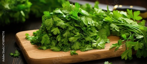A vibrant pile of green parsley leaves perfectly chopped and arranged on a wooden cutting board. The parsley appears fresh and ready to be used for cooking or garnishing dishes.
