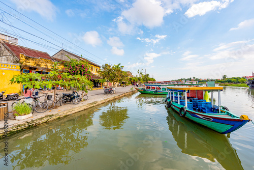 Wallpaper Mural Wooden boats on the Thu Bon River in Hoi An Ancient Town (Hoian), Vietnam. Yellow old houses on waterfront reflected in river. Riverside Scenes in the Historic District of Hoi An, Vietnam Torontodigital.ca
