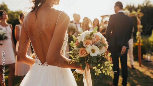 A bride holding a bouquet faces the groom with bridesmaids in the background.