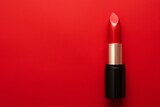 red lipstick on a red background, flat layout, top view. a place for the text.