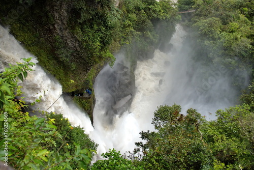 The Pailon del Diablo Waterfall on the Pastaza River falling past a tourist lookout point above the pool, shrouded in mist, in Rio Verde, outside of Banos, Ecuador photo