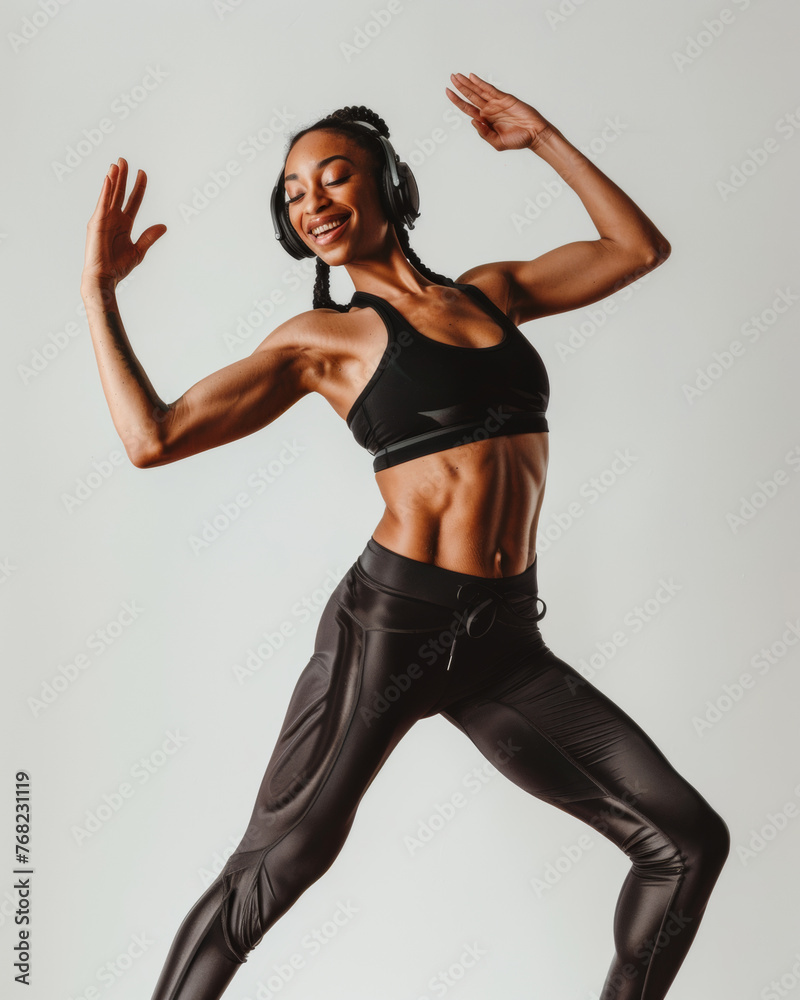Young African American woman in sportswear and headphones smiles and listens to music. Active lifestyle.