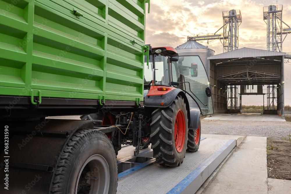Tractor and trailer beside grain silos. Tractor and trailer beside grain silos.