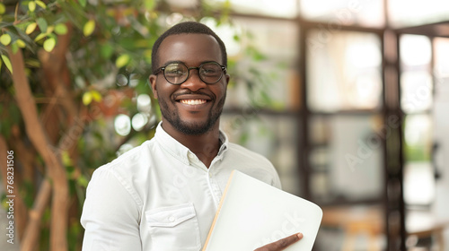 Man holding notebook and smiling in office.