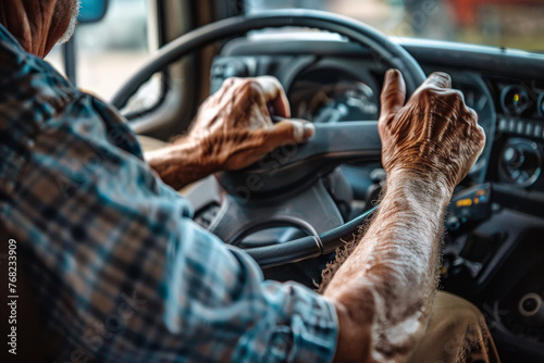 A man is driving a truck with his hands on the steering wheel photo