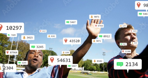 Image of social media notifications over diverse male rugby players in match