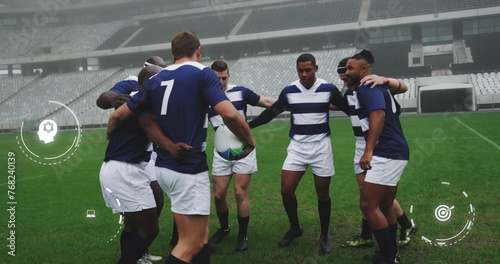 Image of media icons over diverse male rugby team in huddle at stadium