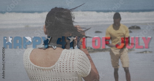 Image of text independence day over african american couple taking photo at beach
