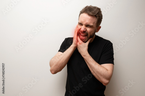 Jaw pain problem concept: bearded hipster middle aged man holds his lower jaw photo