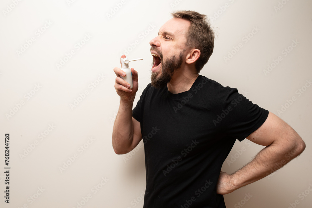 Throat spray used by middle aged bearded hipster man to cure sore throat Throat spray used by middle aged bearded hipster man to cure sore throat