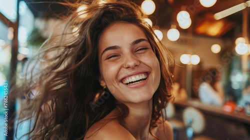 Joyful woman with flowing hair laughing in a beauty salon