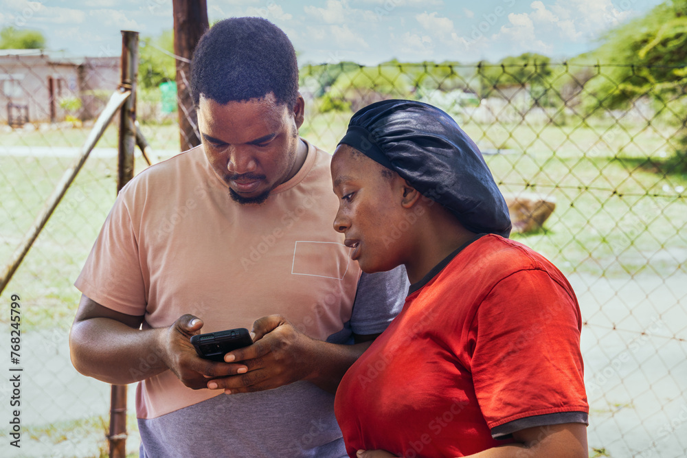 Naklejka premium volunteer teaching a woman how to use the internet in an african village, charity organization