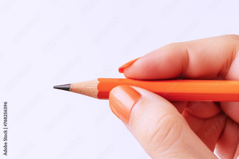 Hand holding a orange pencil, business econonmy financial concept Hand holding a orange pencil, business econonmy financial concept