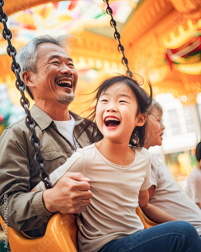Obraz na płótnie Asian granddad, delightful fair moments with granddaughters, swings, carousels, family happiness. w salonie