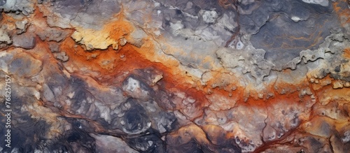 This close-up view showcases a rock with vivid orange and grey colors, displaying a geothermally formed texture found at Yellowstone National Park in Wyoming. The intricate details of the rocks