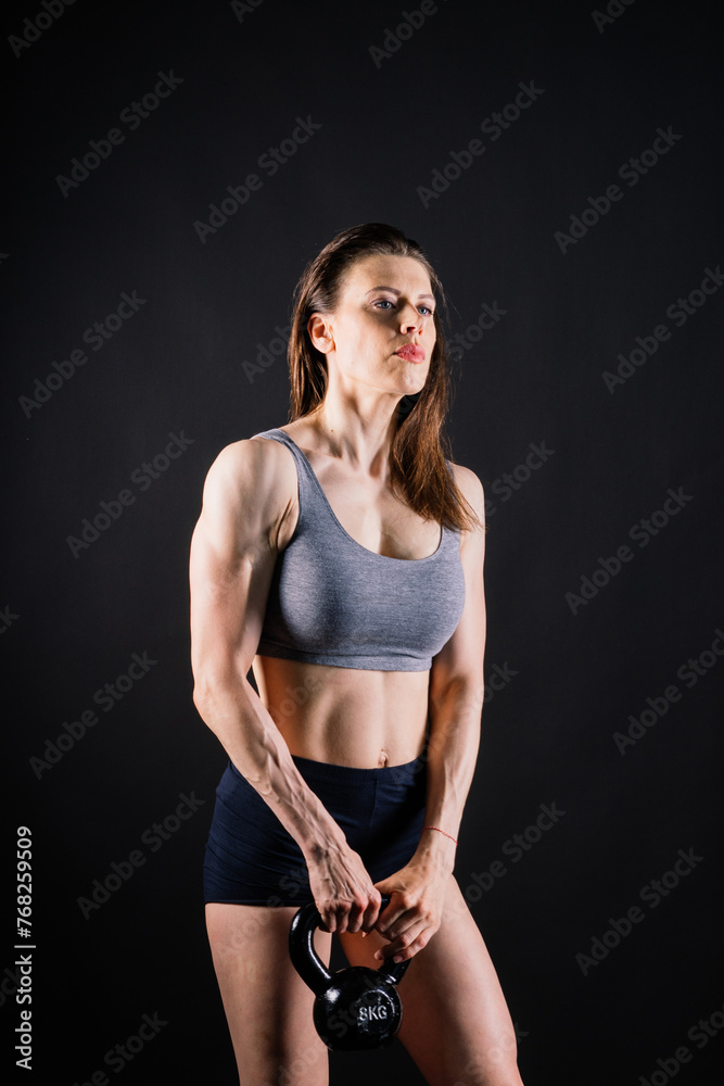 Young female doing swing exercise with a kettle bell. Fitness woman Young female doing swing exercise with a kettle bell. Fitness woman
