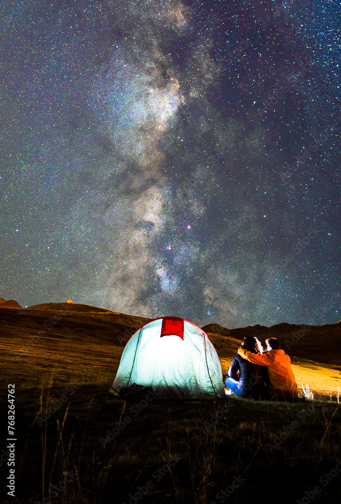 Paisaje de fantasía, pareja enamorada acampados y mirando la galaxia de la Vía Láctea en Andorra.