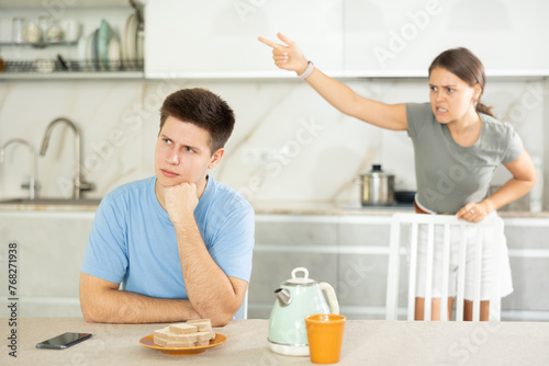 Angry girl swearing to young guy, family quarrel. Family violence, conflicts and relationship problems