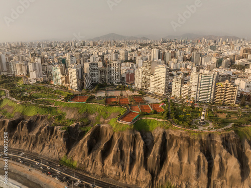An image of the city of Lima showing the boardwalk of Miraflores, the buildings, the lighthouse, the cliff and at the bottom the Costa Verde highway.