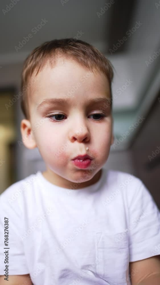 Adorable baby with full mouth chewing his food carefully. Cute little kid eating an apple. Close up. Low angle view. Adorable baby with full mouth chewing his food carefully. Cute little kid eating an apple. Close up. Low angle view.