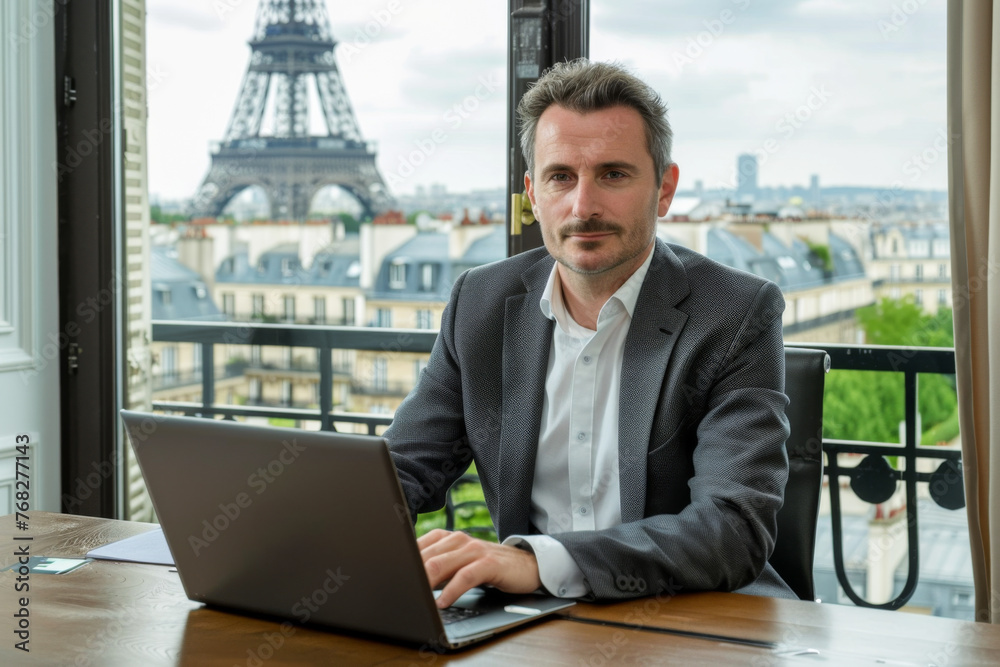 Handsome middle-aged businessman working on his laptop in a cafe or office near the Eiffel tower
Handsome middle-aged businessman working on his laptop in a cafe or office near the Eiffel tower