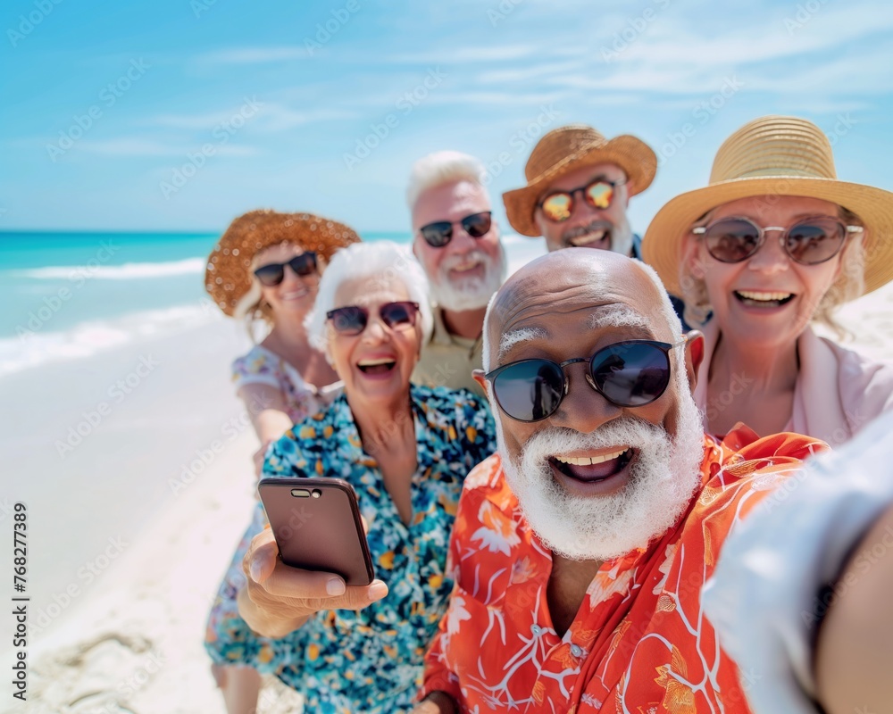 Group of retired men and women with hats and sunglasses, enjoying the vacations, taking a selfie on the beach, cheerful and carefree