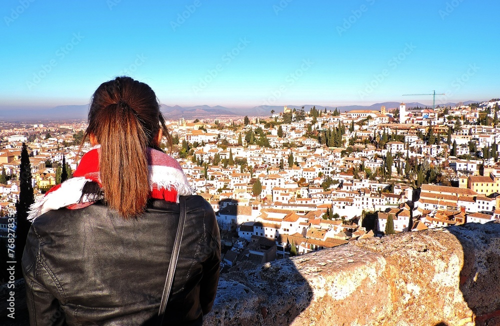 Joven turista contemplando la ciudad de Granada desde la Alhambra.