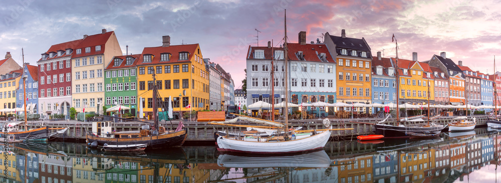 Panorama of Nyhavn with colorful facades of old houses and ships in Old Town of Copenhagen, Denmark.