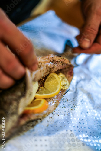 Preparing trouts with lemons butter and green dill. 