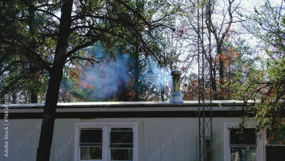 Smoke wafting from manufactured house chimney while burning wood in