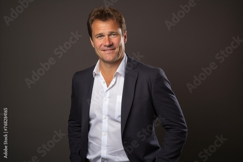 Portrait of a smiling businessman on a dark background. Studio shot.