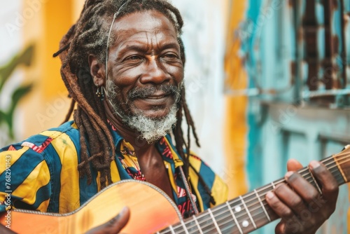 Joyous Rastafarian man with dreadlocks plays guitar on the street, his smile reflecting the soulful sound of music