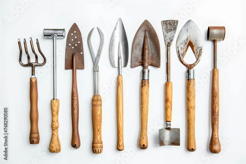 A collection of well-used garden tools, such as a fork, trowel, and spade, laid out meticulously on a white surface
