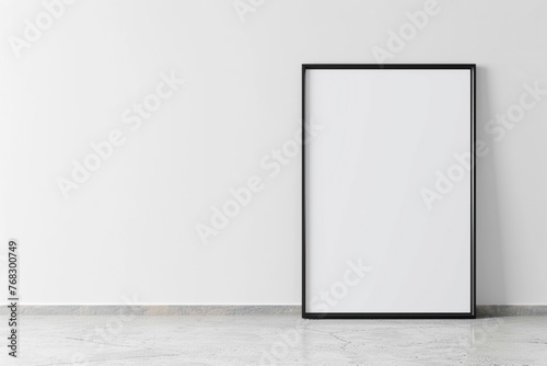 photograph of a poster frame leaning against a minimalist white wall  ready for graphic posters or advertising content 