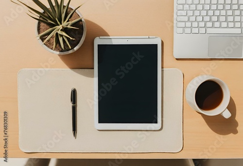 Top view of a minimalist desk with a tablet and pens on it