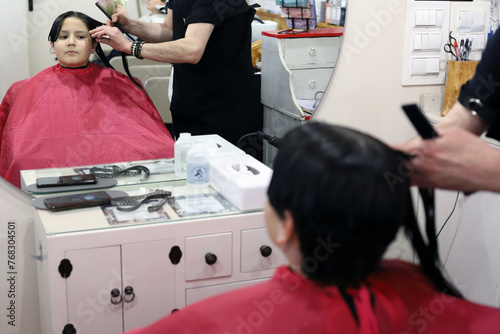 niño con el pelo largo cortándolo en la peluquería para donarlo para hacer pelucas para personas enfermas de cáncer photo