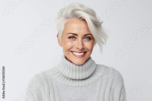 Portrait of happy mature woman in sweater, isolated on grey background