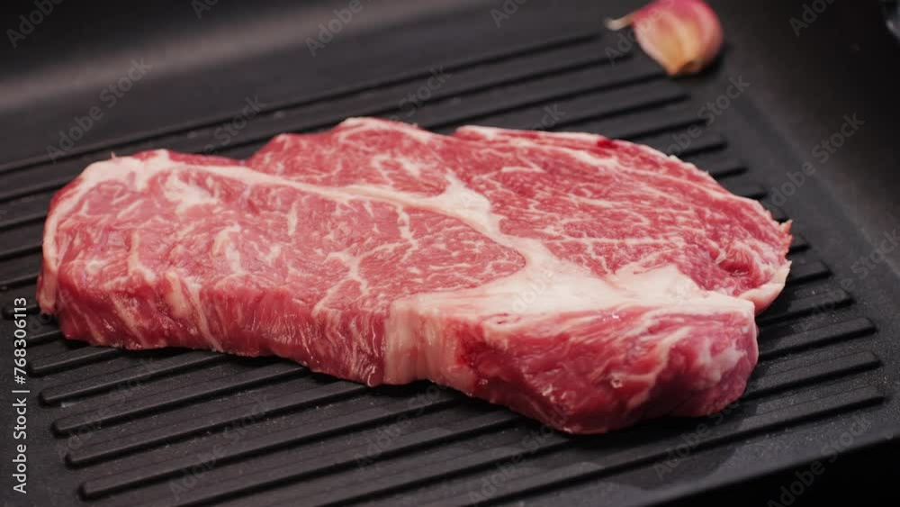 Fresh marbled beef with pepper, salt and rosemary close-up macro. Preparation to cook juicy steak on grill. Premium organic raw wagyu meat Fresh marbled beef with pepper, salt and rosemary close-up macro. Preparation to cook juicy steak on grill. Premium organic raw wagyu meat