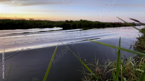 Hydrofoil rider gliding over the water with his board in one of the canals of the Ria de Aveiro in Portugal during sunset. photo