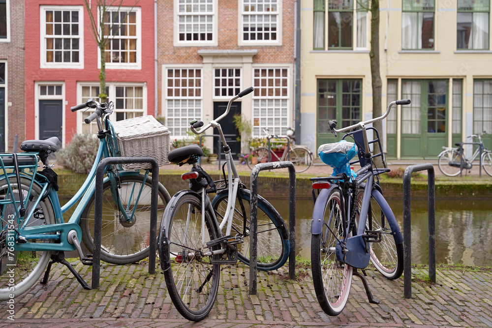 Picturesque Netherlands. Bicycles parked alongside a channel on beautiful old buildings background.