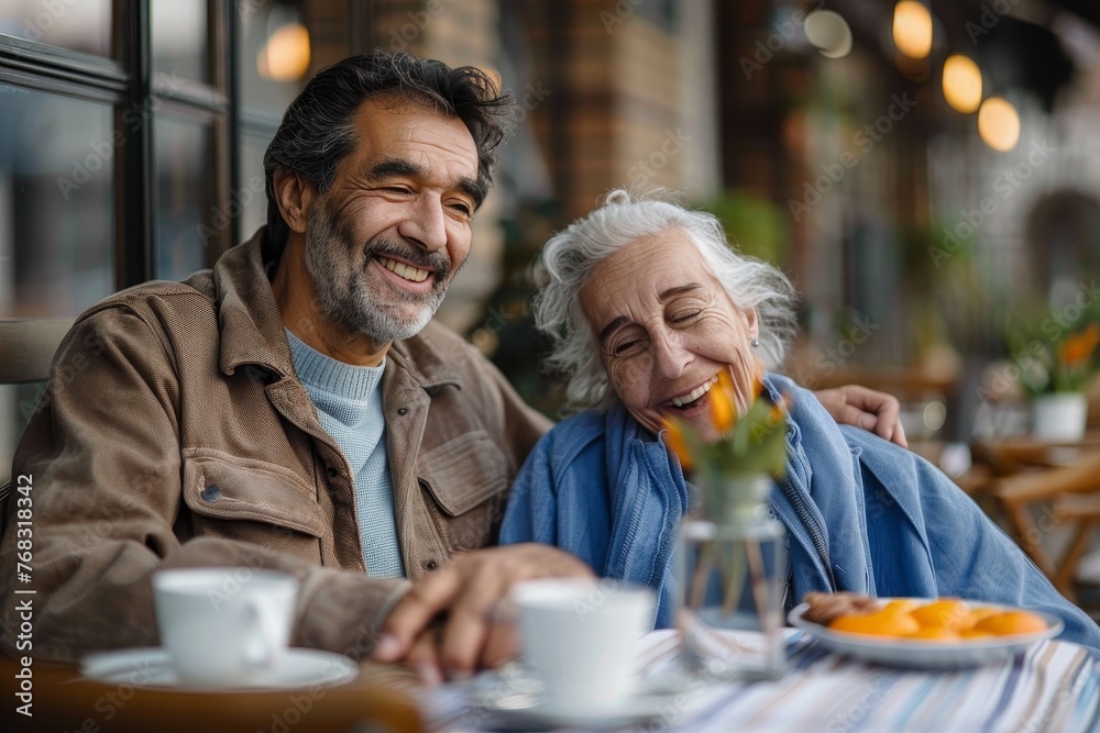 Elderly man and middle-aged man sharing a meal and smiles at a cafe Elderly man and middle-aged man sharing a meal and smiles at a cafe